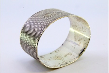 Argola de guardanapo em prata de forma oval guilhochada envolvendo cartela para monograma.